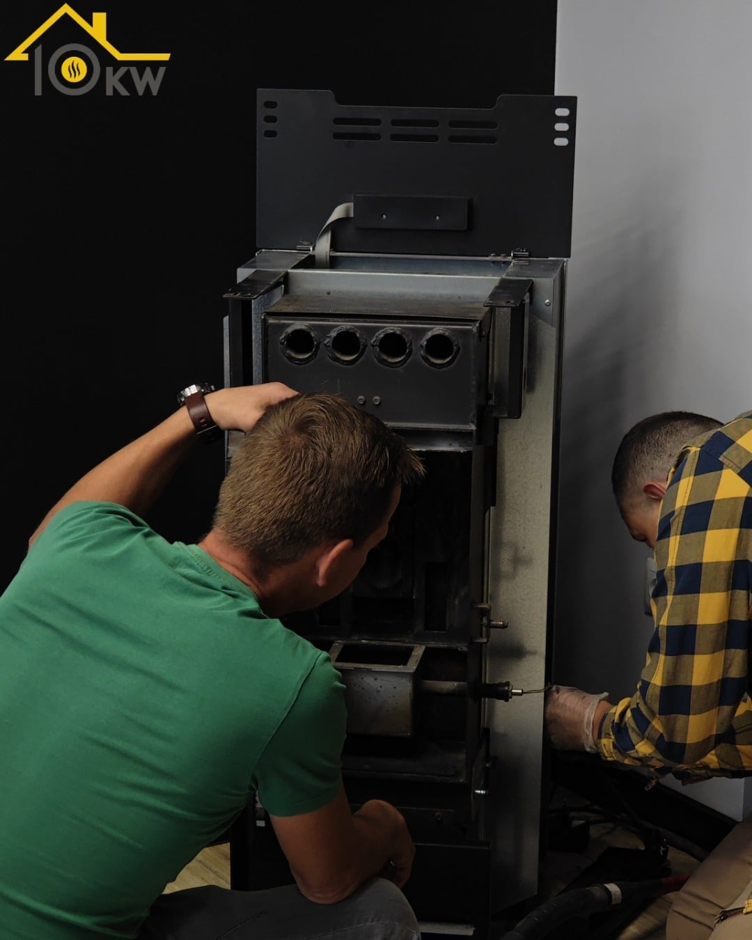 dwóch mężczyzn montujących kominek na pellet z płaszczem wodnym